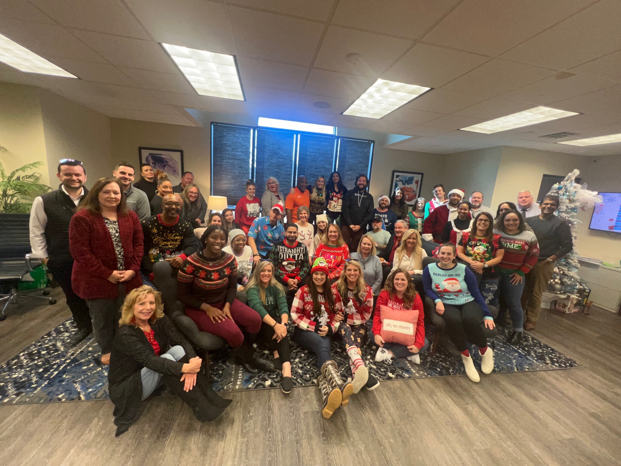 A group celebrating together in festive holiday sweaters